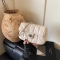 Beige quilted crossbody bag with silver chain strap and metal swivel lock detail - Off White