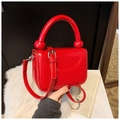Detail of red patent leather mini bag featuring unique round handle and silver hardware - Red