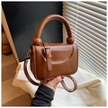 Detail of brown patent leather square handbag with round handle and metal buckle strap - Brown