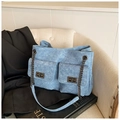 Détail d'un sac bandoulière en denim bleu avec motif matelassé et verrous en métal vintage - Bleu foncé