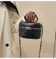 Mini black quilted leather handbag with gold chain strap and top handle shown on model - Black