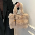 Borsa tote in ecopelliccia beige con ciondolo a campanello portata da una modella in cappotto - Cachi
