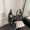 Borsa a mezzaluna nera lucida alla moda con ciondolo a sfera d'argento e tracolla - Nero
