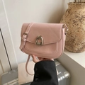Borsa a sella rosa minimalista da donna con fibbia argento su sfondo di valigia chic - Rosa