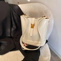 Chic white leather bucket bag with gold metal clasp on a soft fabric seat - Off White