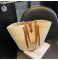 Detail of a large straw tote bag with brown leather handles on a modern chair - One Size / White
