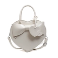 White heart-shaped handbag with large bow decoration and adjustable shoulder strap - White
