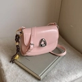 Pink faux leather saddle bag with silver U-shaped buckle and brown woven charm - Pink With Pendant