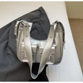 Silver metallic Y2K shoulder bag with dual flap pockets and wide eyelet strap on grey blazer - Silver