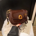Glossy burgundy saddle bag with gold horseshoe buckle and adjustable leather strap - Brown with Pendant