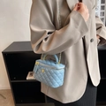 Borsa a scatola trapuntata azzurra con manico in metallo dorato indossata da modella - Blu