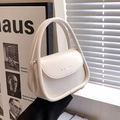 Borsa a mano moderna bianco crema con manico curvo e scritte dorate nella luce - Bianco