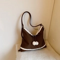 Détail du sac en similicuir marron foncé avec bordure en molleton blanc et nœud à pompons - Marron