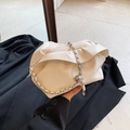Chic off-white pleated dumpling bag with silver chain strap shown in a modern setting - White