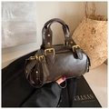 Borsa marrone scuro vintage con fibbie dorate e borchie in un ambiente di vita retrò - Marrone