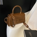 Borsa a mano vintage marrone con fibbia dorata e tracolla in un ambiente elegante - Marrone