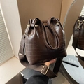 Dettaglio borsa a secchiello marrone scuro effetto coccodrillo con finiture dorate - Marrone