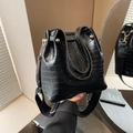 Dettaglio borsa a secchiello nera coccodrillo con fibbie d'oro e tracolla larga - Nero