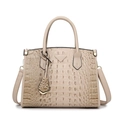 Beige faux crocodile skin tote bag with dual handles and crossbody strap in studio light - Khaki
