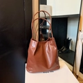Detailed view of the brown synthetic leather tote bag with soft folds and glossy finish - Brown