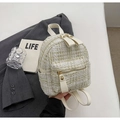 Detailed view of white and gold tweed mini backpack with leather straps and gold metal zipper - White