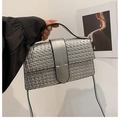 Silver woven shoulder bag with lock buckle held by model for stylish commuting - Silver