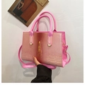 Makroaufnahme der rosa Krokodilstruktur und des 3D-Kopfdetails der Umhängetasche - Rosa