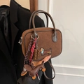 Borsa a tracolla in camoscio marrone con ricamo bassotto e ciondoli di design in mano - Con Ciondolo / caffè