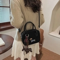Borsa a tracolla nera con ricamo bassotto e ciondoli su outfit con maglione in maglia - Con Ciondolo / Nero
