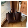Deep brown matte tote bag with gold buckle on wooden windowsill in retro style - Brown