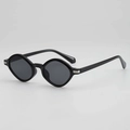 Polished black irregular polygon sunglasses with silver metal accents on grey background - Black Frame Grey Lens
