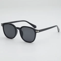 Schwarze Retro-Sonnenbrille mit runden Gläsern und silbernen Metalldetails in 45-Grad-Ansicht - Schwarzer Rahmen Graue Gläser
