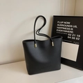 Minimalist black pebble leather bucket bag with gold hardware and slim straps - Black