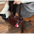 Detail of burgundy faux leather handbag with silver hardware and baseball keychain - Red with Pendant