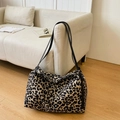 Détail du sac cabas en toile à motif léopard avec bandoulières noires sur parquet - Imprimé Léopard Foncé