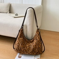 Dettaglio della borsa a mezzaluna leopardata con tracolla marrone su divano - Leopardo Chiaro