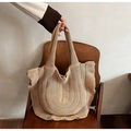 Beigefarbene Strick-Tasche mit Rüschen-Dekor auf einem Vintage-Holzstuhl präsentiert - Khaki