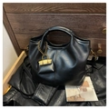 Dettaglio borsa in pelle opaca nera con ciondolo decorativo a catena dorata e tracolla - Nero