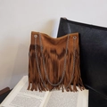 Bohemian braune Fransentasche mit Silberketten auf einem Vintage-Buchhintergrund - Braun