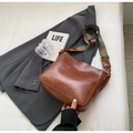 Brown bucket bag with retro embroidered wide strap shown on a dark gray blazer background - Brown
