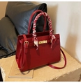 Detail of red crocodile texture handbag with gold clasp and silk scarf wrapped handle - Burgundy