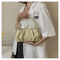 Chic yellow pleated cloud bag with elegant handle worn by model in casual white suit - Yellow