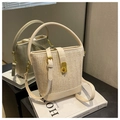 Creamy beige woven straw bucket bag with herringbone pattern and gold turn-lock closure - White