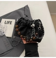 Dettaglio della borsa a secchiello in velluto nero con perle ambra e tracolla a catena - Nero