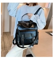Zaino moderno in pelle PU nera lucida con fibbie indossato dalla modella - Nero