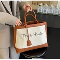 Beige canvas and brown leather tote bag with Frida Kahlo script and dual handles - White