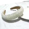 Detail of white crystal beads on a padded sponge headband for bridal fashion hair styling - White