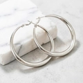 Élégantes créoles en argent poli pour femmes sur un fond en marbre gris chic - 4mm / Argenté