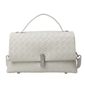 White woven leather crossbody bag with silver clasp and top handle on white background - White