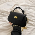 Minimalist black leather crossbody bag with gold twist handle and chunky chain strap - Black